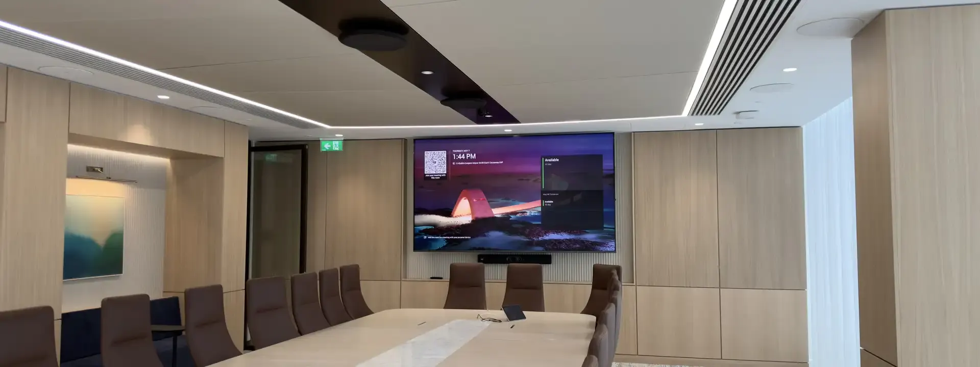 Business AV installation: boardroom with a wall screen and video bar at the end of a long table