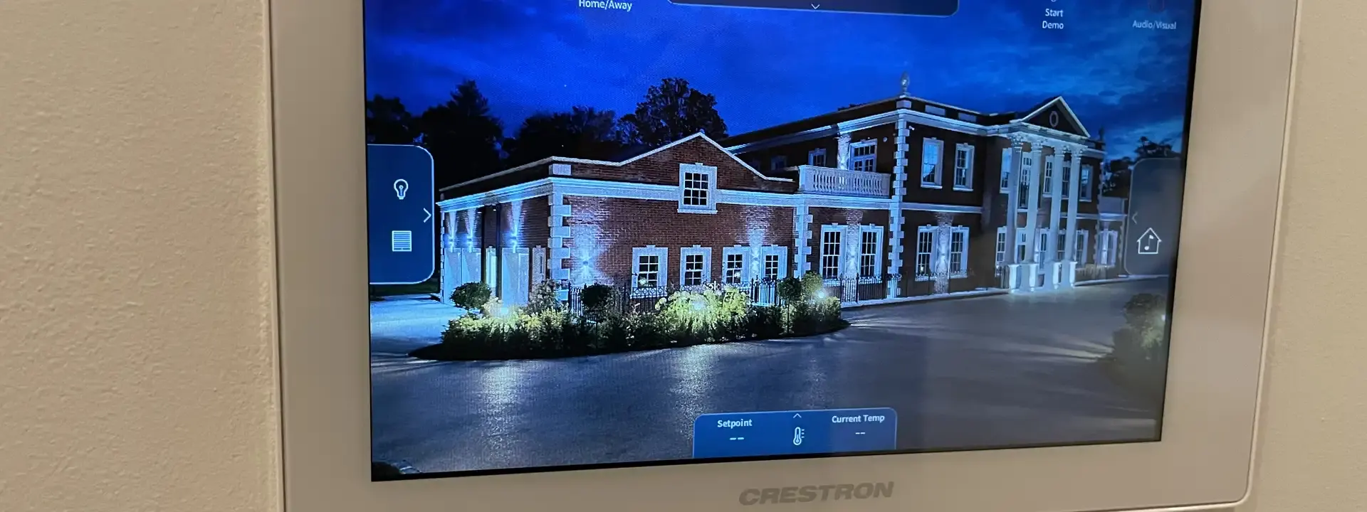 AV installation example: Crestron touch panel on a wall showing a home control screen
