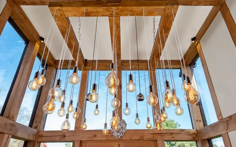 Pendant filament bulbs hanging from an oak framed glass ceiling